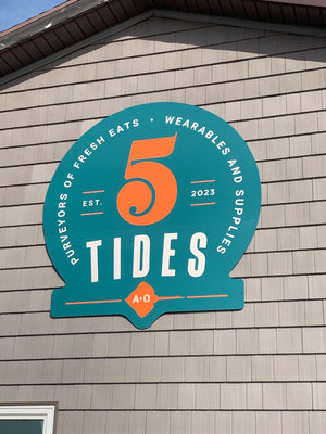 a 2D-style teal sign with white and orange lettering for 5 Tides