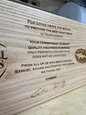 a closeup photo of a wooden plank showing the laser engraved text
