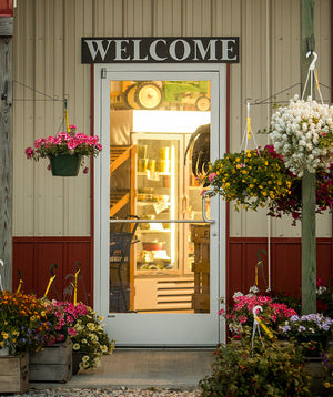a photo of a door with a rectangular "Welcome" sign mounted above it