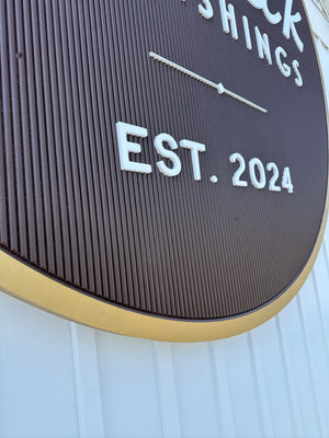 a closeup photo of the circular Fenwick Furnishings sign