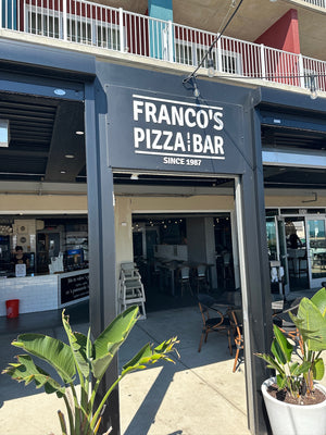 A photo of a navy blue sign with white text mounted above a door