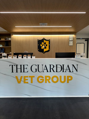 Front desk of The Guardian Vet Group with a logo on the wall.