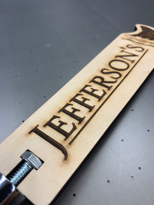 a closeup photo of the Jefferson's tap handle showing the laser engraved text