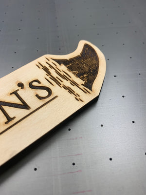 a closeup photo of the Jefferson's tap handle showing the laser engraved shark fin logo on top