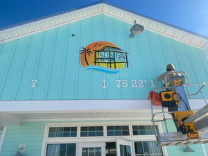 a photo of Wyatt installing the latitude & longitude numbers on the front of a building