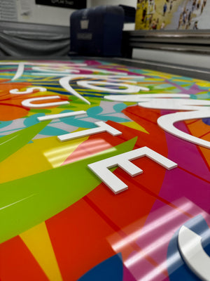 an angled closeup of the Kokomo Suites sign showing the raised white lettering on a colorful acrylic background