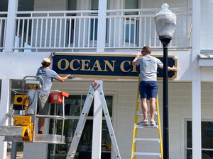 a photo of Wyatt and another guy installing the Museum of Ocean City sign