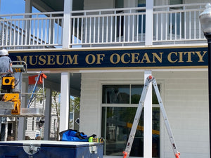 a photo of Wyatt installing the Museum of Ocean City sign