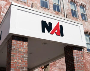 a photo of the NAI Coastal sign mounted above the entrance