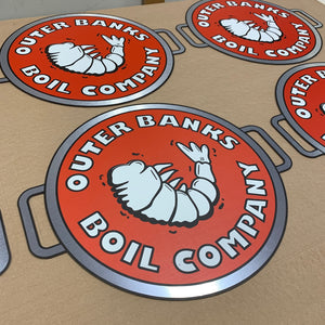 a photo of the Outer Banks Boil Company logos on a table