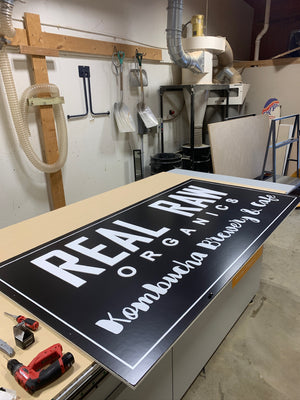 a photo of the Real Raw Organics sign on the CNC machine