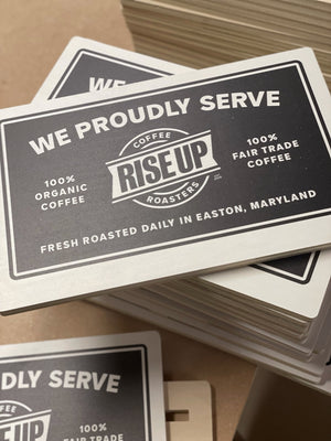 a photo of a small stack of Rise Up Coffee signs