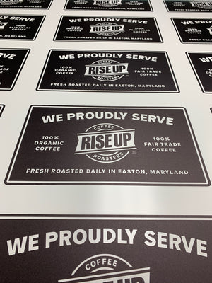 a photo of Rise Up Coffee signs printed on a sheet of uncut material
