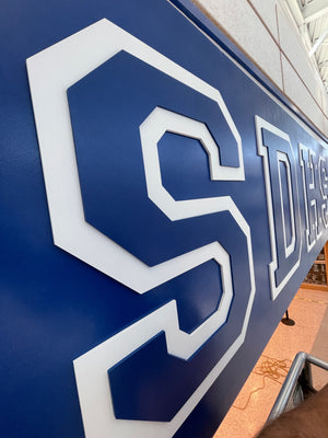 an angled photo of the SDHS letters mounted above a main hallway, showing the layers on the lettering