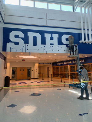 a photo of the installation of the SDHS hallway lettering