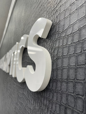 an angled photo showing the raised lettering for The Look Optics mounted on an interior wall
