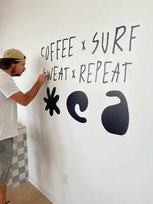 a photo of Wyatt mounting The Stoke's lettering to the walls