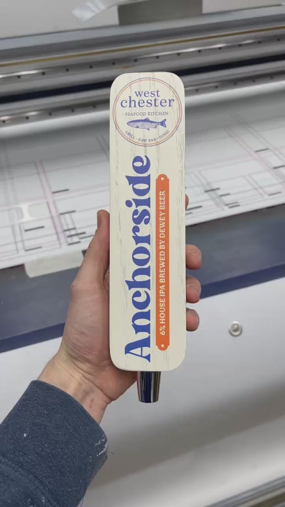 a turnaround video of a tap handle with a white background, blue and orange lettering, and the West Chester Seafood Kitchen logo